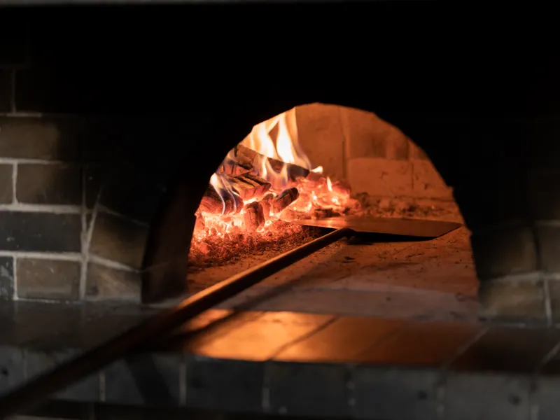 The wood-fired oven at the back of the kitchen, lit and up to temperature.